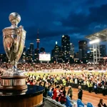 Silberne MLS Cup Trophäe vor einer beleuchteten Stadion-Skyline bei Nacht